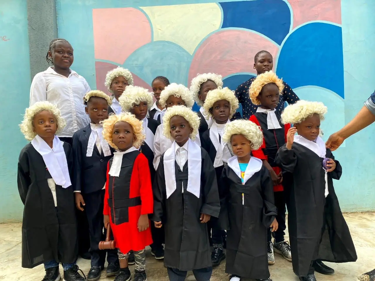 Pupils in barrister wigs and gowns holding a gavel on Career Day