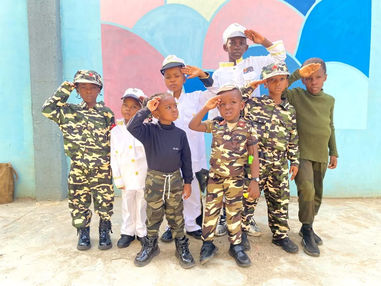 Pupils in army, navy and air force uniforms saluting on Career Day